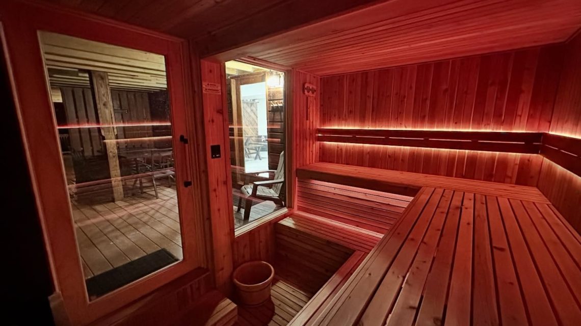 Old Mill Village Camp 5 Wooden sauna with ambient lighting.